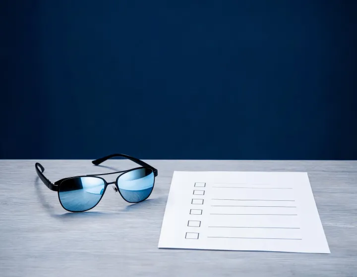 Prescription mirrored sunglasses brief checklist on a sourcing desk